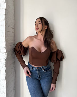 brunette woman in brown off shoulder top and jeans
